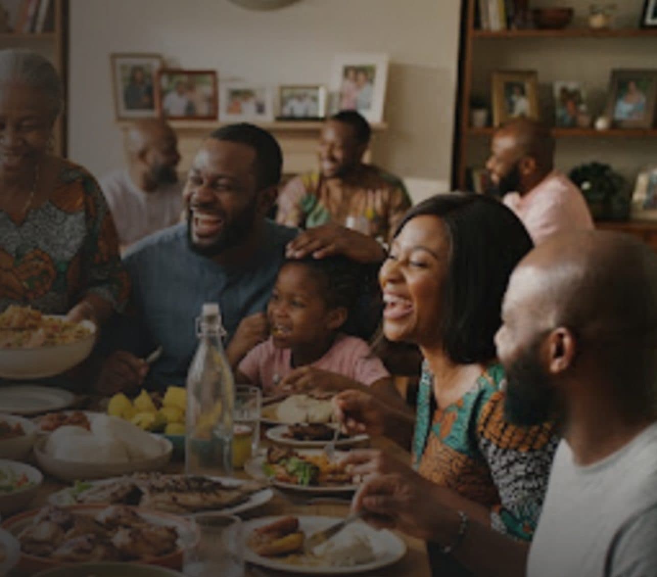 A family laughing together around a full dinner table